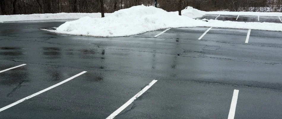 Clear parking lot in Boston, MA, with snow piles.